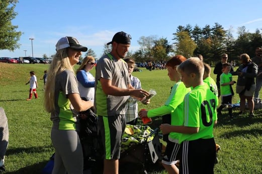 Photo of an NCB employee coaching children's soccer