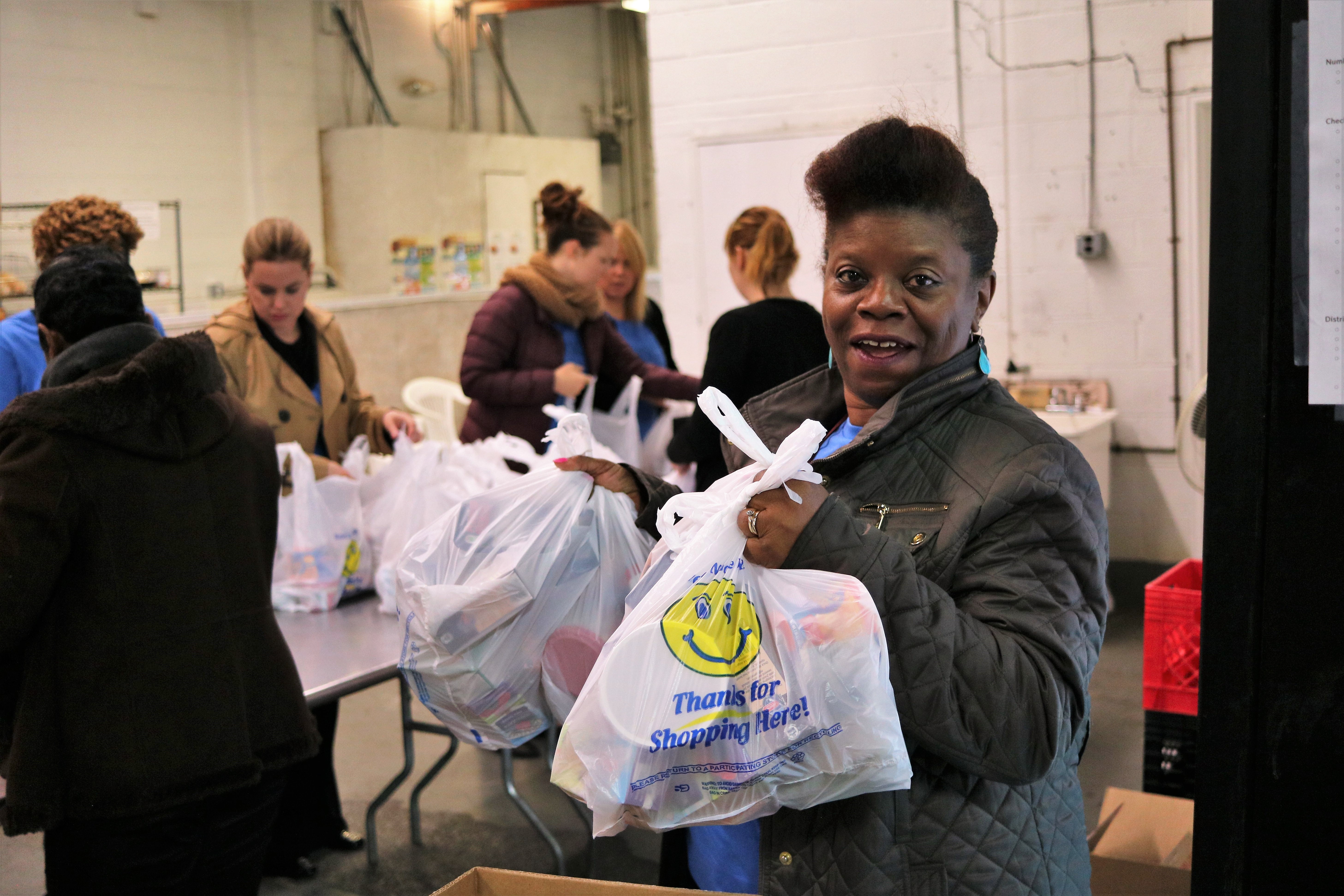 Photo of an NCB employee volunteering at a nonprofit by packing back of food to be distributed to children