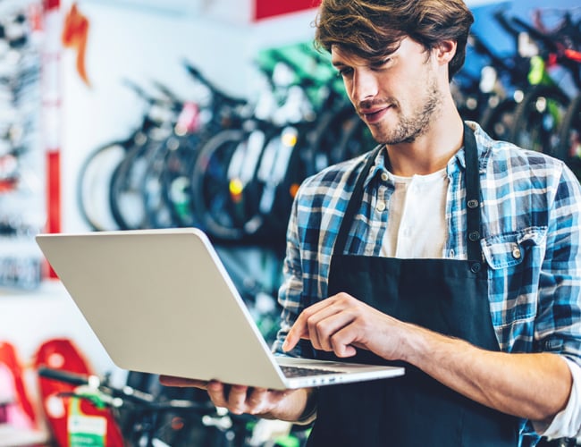 bicycle shop owner on laptop