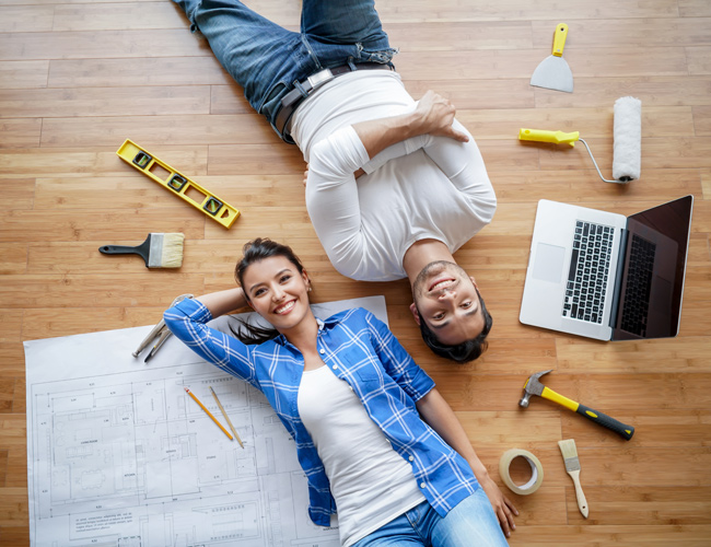 couple laying on the floor with remodeling items scattered around